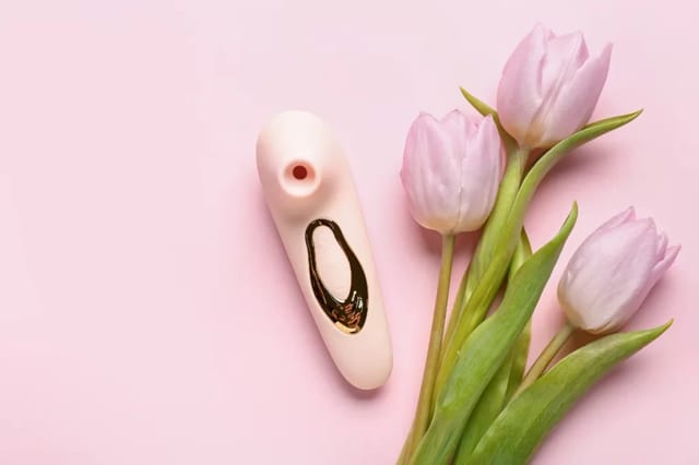 cream-vibrator-with-pink-tulips Cream vibrator styled with pink tulips on a soft pink background