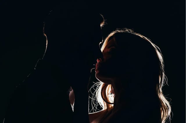 romantic-couple-silhouette-closeup Dramatic low-light silhouette of an adult couple in a romantic close-up moment.