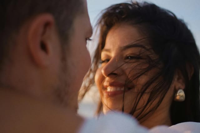 romantic-couple-smiling-outdoors Romantic couple smiling at each other outdoors in warm natural light