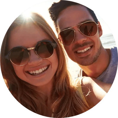 Smiling couple taking a beach selfie at sunset