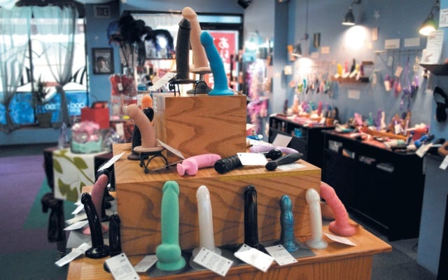 Well-lit sex toy store with bright dildos and other sex toys on display